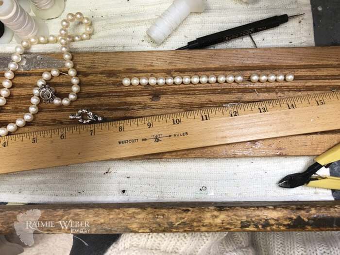 Pearl necklaces stretched out next to a ruler