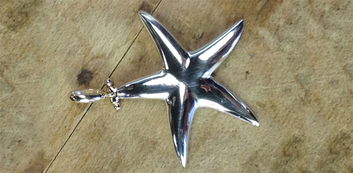 we added an articulated bail in 14k yellow gold to this simple sterling silver starfish pendant