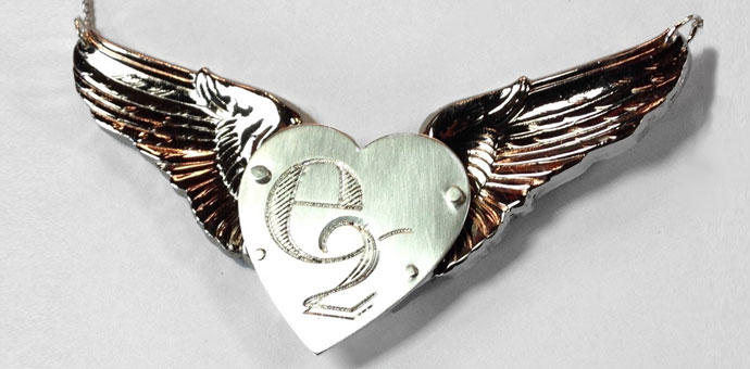 the final pendant - silver heart engraved with e-2, riveted to his squadron wings from first deployment