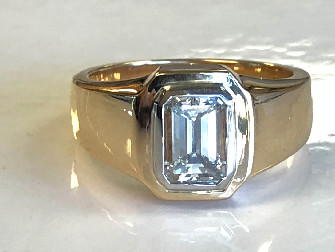 emerald cut diamond set vertically in a platinum bezel