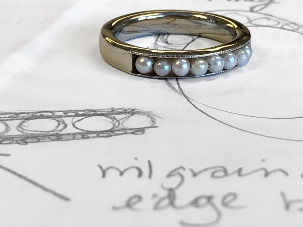 channel ring sitting on top of Raimie's design sketches